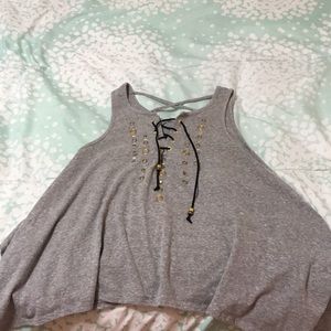 A grey tank top shirt with studs on it